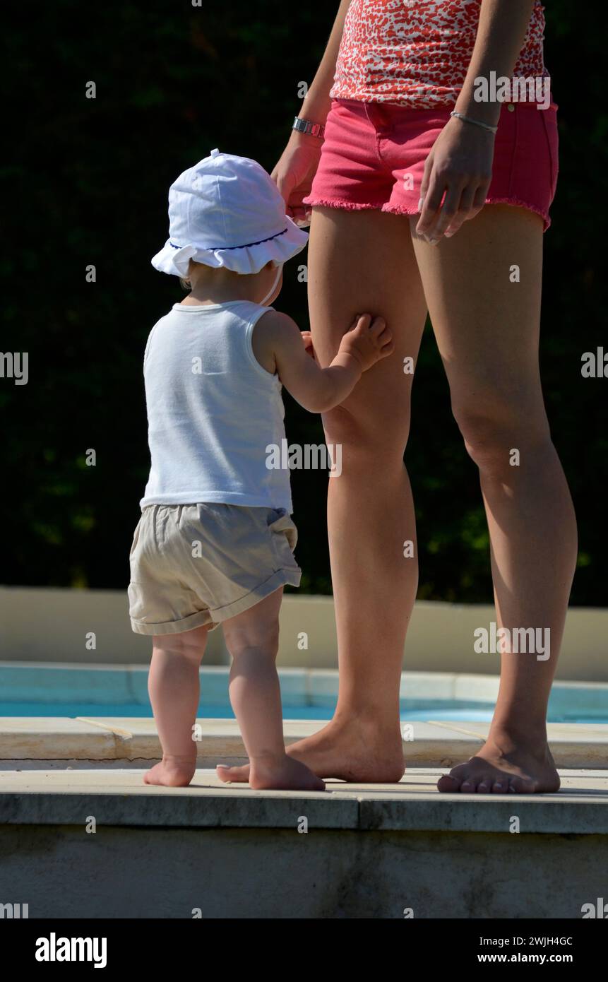 bimbo e madre in piedi insieme alla luce del sole Foto Stock