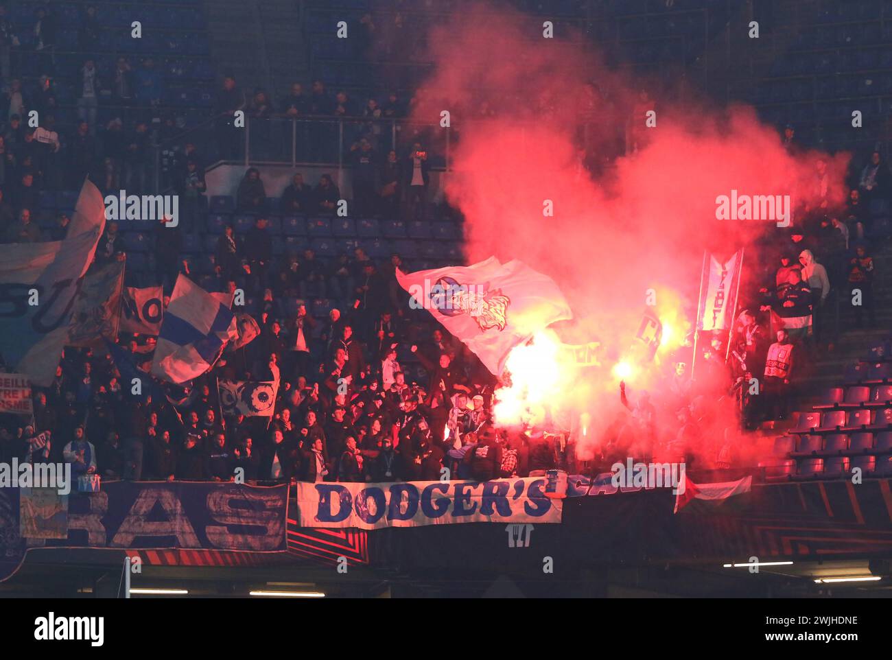 Amburgo, Germania - 15 febbraio 2024: I tifosi di Marsiglia bruciano le fiamme e mostrano il loro sostegno durante la partita di UEFA Europa League contro lo Shakhtar Donetsk al Volksparkstadion di Amburgo, Germania Foto Stock