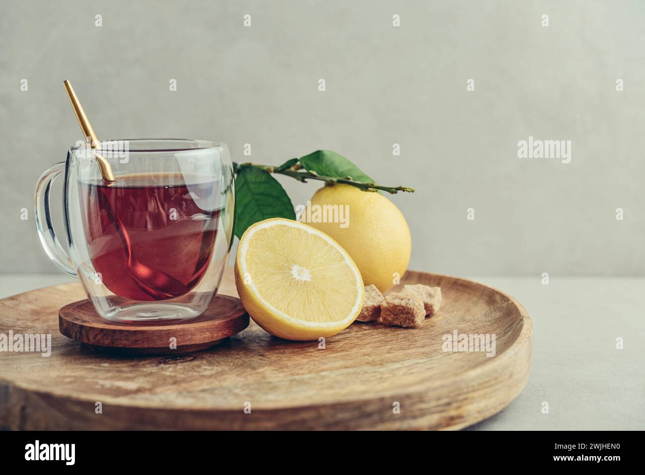 Tè in una tazza di bicchiere con frutti di arancia freschi di bergamotto su sfondo chiaro Foto Stock