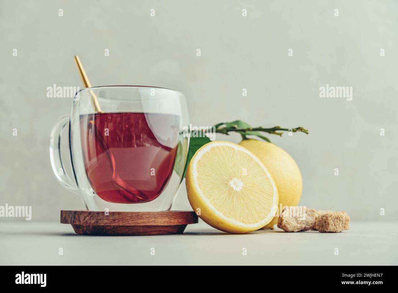 Tè in una tazza di bicchiere con frutti di arancia freschi di bergamotto su sfondo chiaro Foto Stock