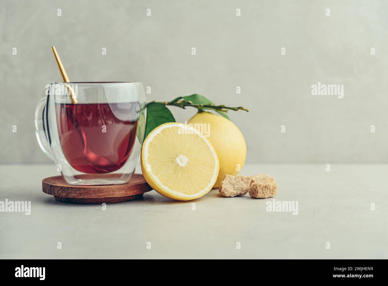 Tè in una tazza di bicchiere con frutti di arancia freschi di bergamotto su sfondo chiaro Foto Stock