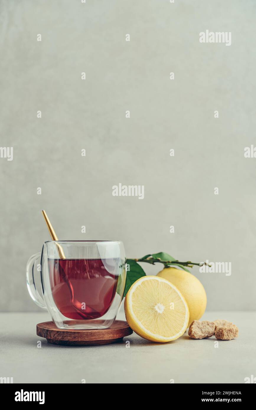 Tè in una tazza di bicchiere con frutti di arancia freschi di bergamotto su sfondo chiaro Foto Stock