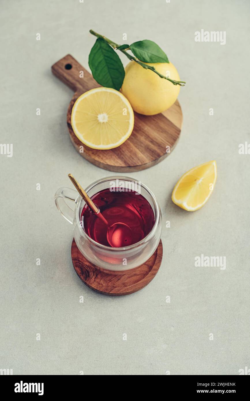 Tè in una tazza di bicchiere con frutti di arancia freschi di bergamotto su sfondo chiaro Foto Stock