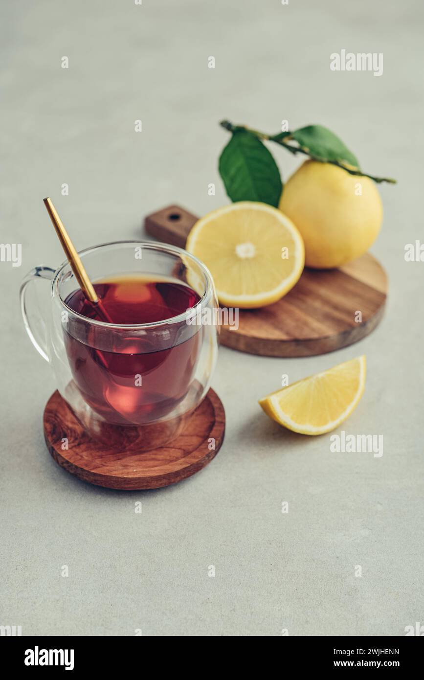 Tè in una tazza di bicchiere con frutti di arancia freschi di bergamotto su sfondo chiaro Foto Stock