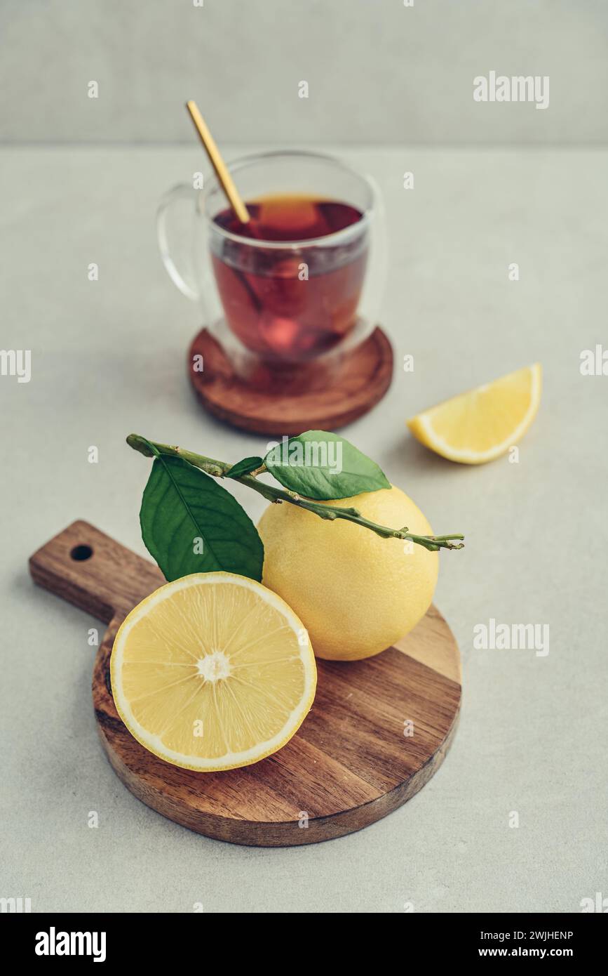 Tè in una tazza di bicchiere con frutti di arancia freschi di bergamotto su sfondo chiaro Foto Stock