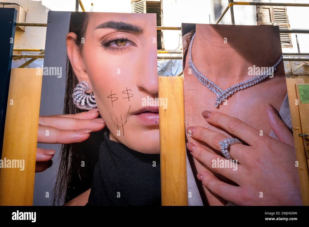 Una pubblicità vandalizzata di moda dipinta con segni di dollaro e un sorriso Foto Stock