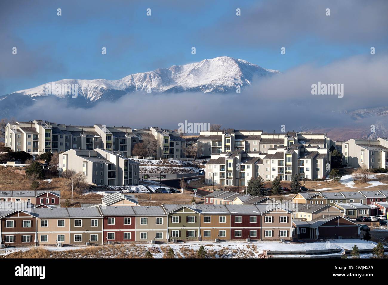 Una tempesta invernale sgorga sul Pikes Peak a Colorado Springs. Appartamenti, case a schiera e condomini ai piedi offrono splendide viste sulle montagne. Foto Stock
