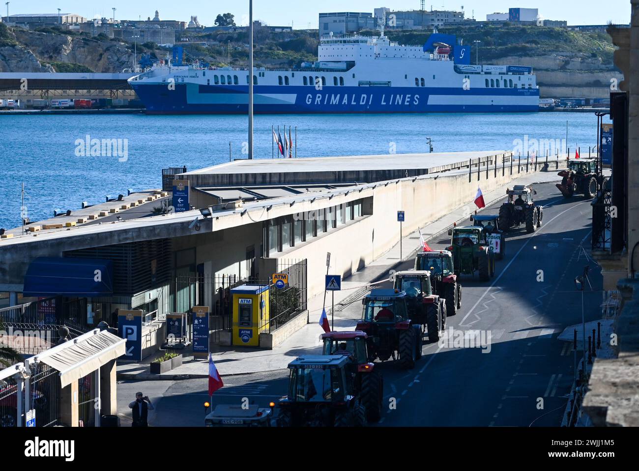La Valletta. 15 febbraio 2024. La foto scattata il 15 febbraio 2024 mostra i trattori che guidano su una strada durante una protesta degli agricoltori a la Valletta, Malta. Gli agricoltori maltesi hanno organizzato una nuova ondata di proteste giovedì, chiedendo più sostegno economico dal loro governo e ribadendo l'opposizione ad alcune politiche dell'Unione europea relative all'agricoltura e alla protezione dell'ambiente. Credito: Jonathan Borg/Xinhua/Alamy Live News Foto Stock
