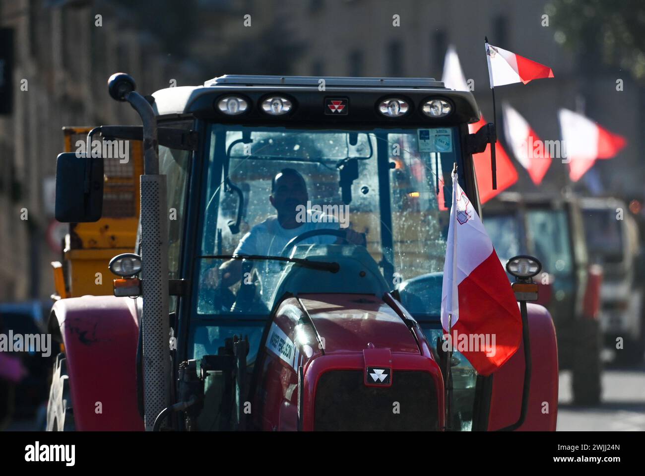 La Valletta. 15 febbraio 2024. La foto scattata il 15 febbraio 2024 mostra i trattori che guidano su una strada durante una protesta degli agricoltori a la Valletta, Malta. Gli agricoltori maltesi hanno organizzato una nuova ondata di proteste giovedì, chiedendo più sostegno economico dal loro governo e ribadendo l'opposizione ad alcune politiche dell'Unione europea relative all'agricoltura e alla protezione dell'ambiente. Credito: Jonathan Borg/Xinhua/Alamy Live News Foto Stock