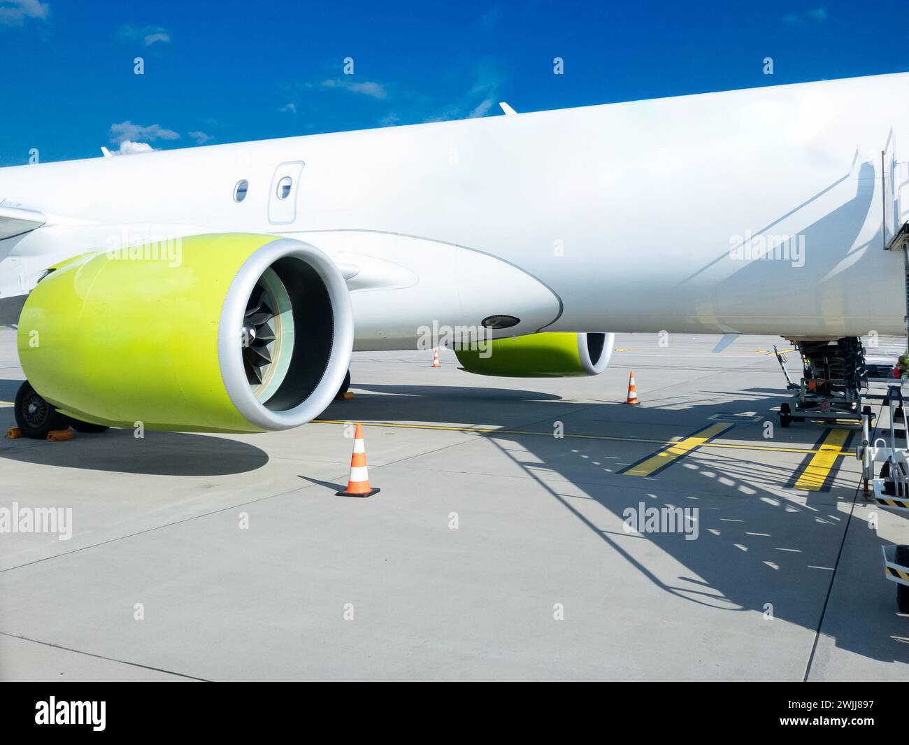 Sull'asfalto di un vivace aeroporto europeo, un elegante aereo da carico attende il suo prossimo viaggio. Il grande motore dell'aereo, colorato in modo sorprendente, suggerisce il Foto Stock