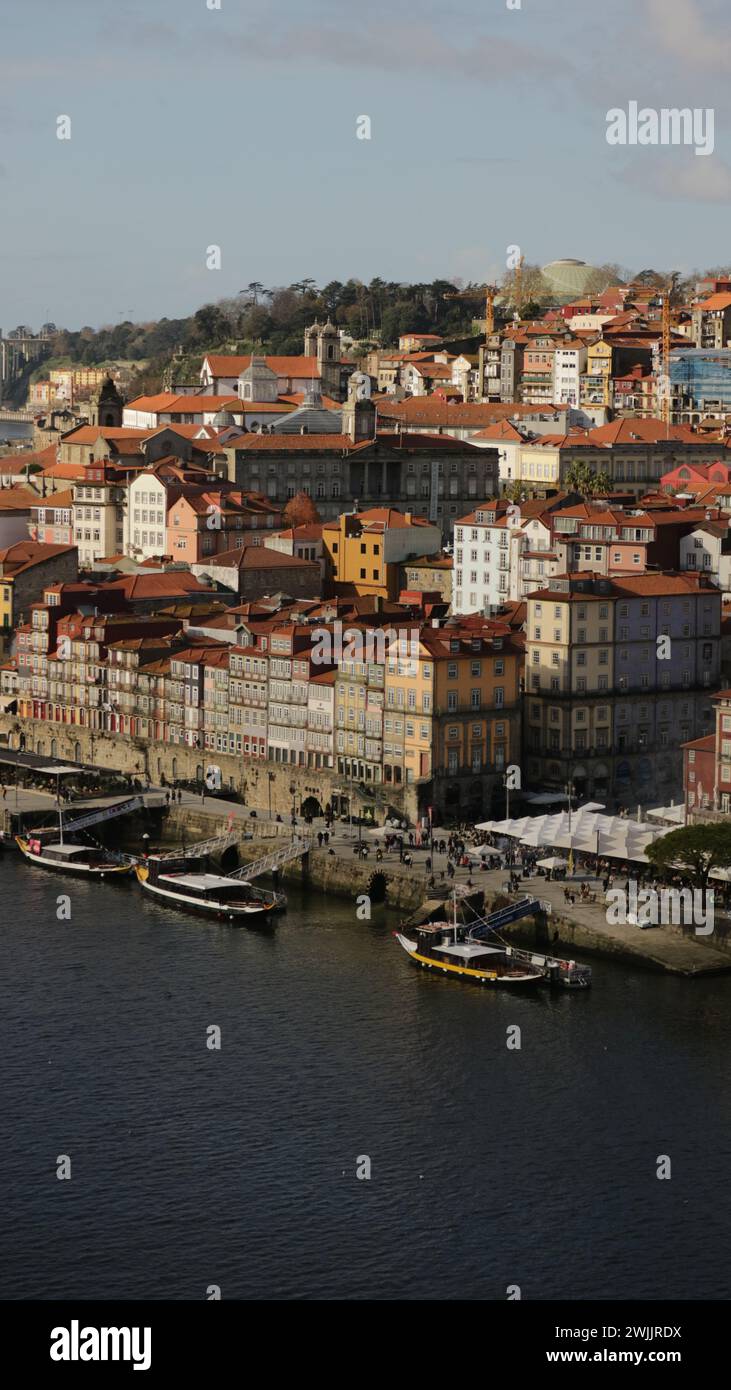 Più barche navigano su un fiume con un paesaggio urbano sullo sfondo Foto Stock