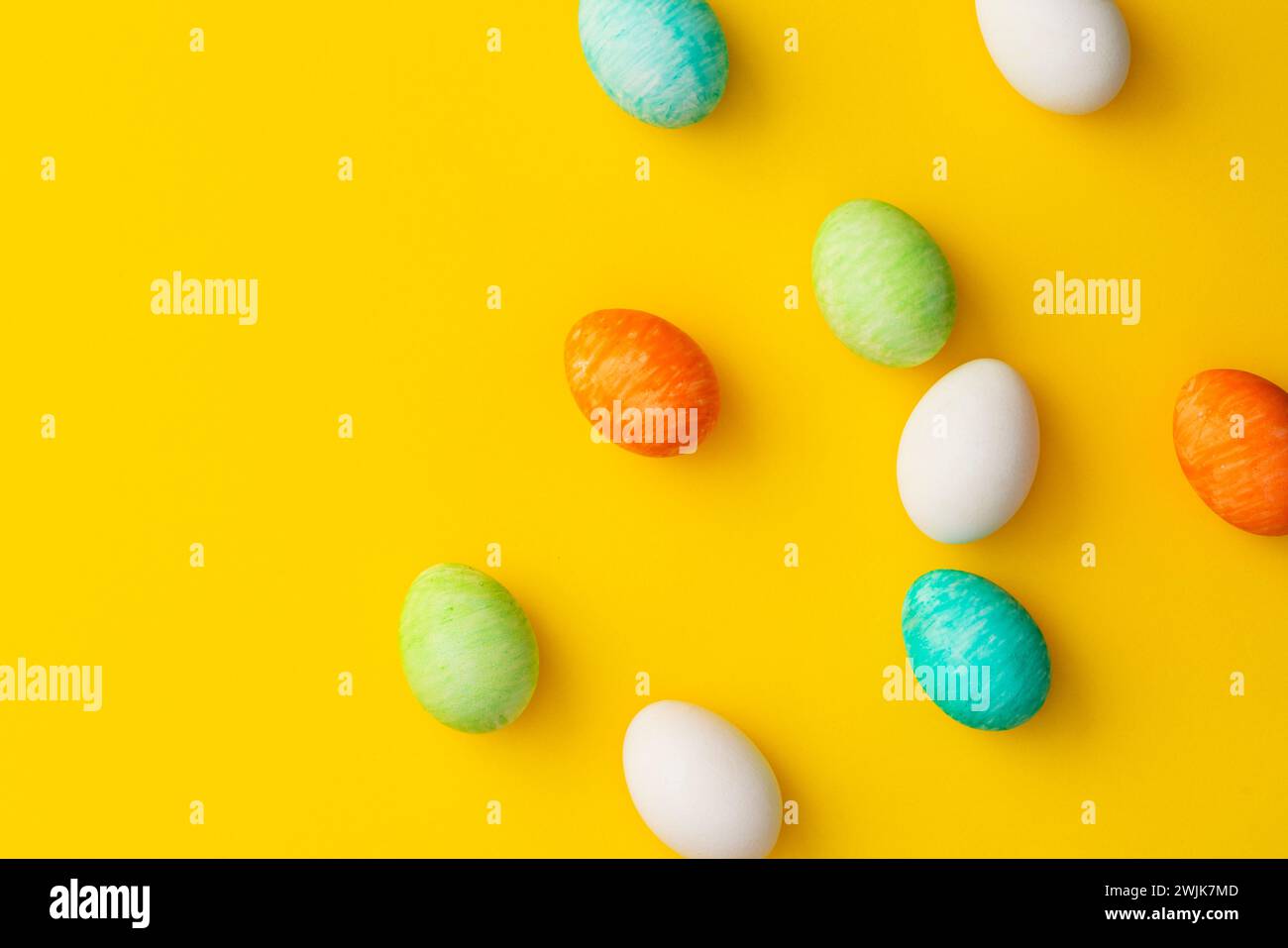 Uova di pasqua colorate dipinte a mano su sfondo giallo. Direttamente sopra l'immagine del piano d'esame. Foto Stock