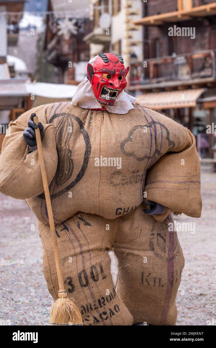 Reveller indossa maschera di legno e costume di carnevale. Evolene, Canton Vallese, Svizzera. Foto Stock