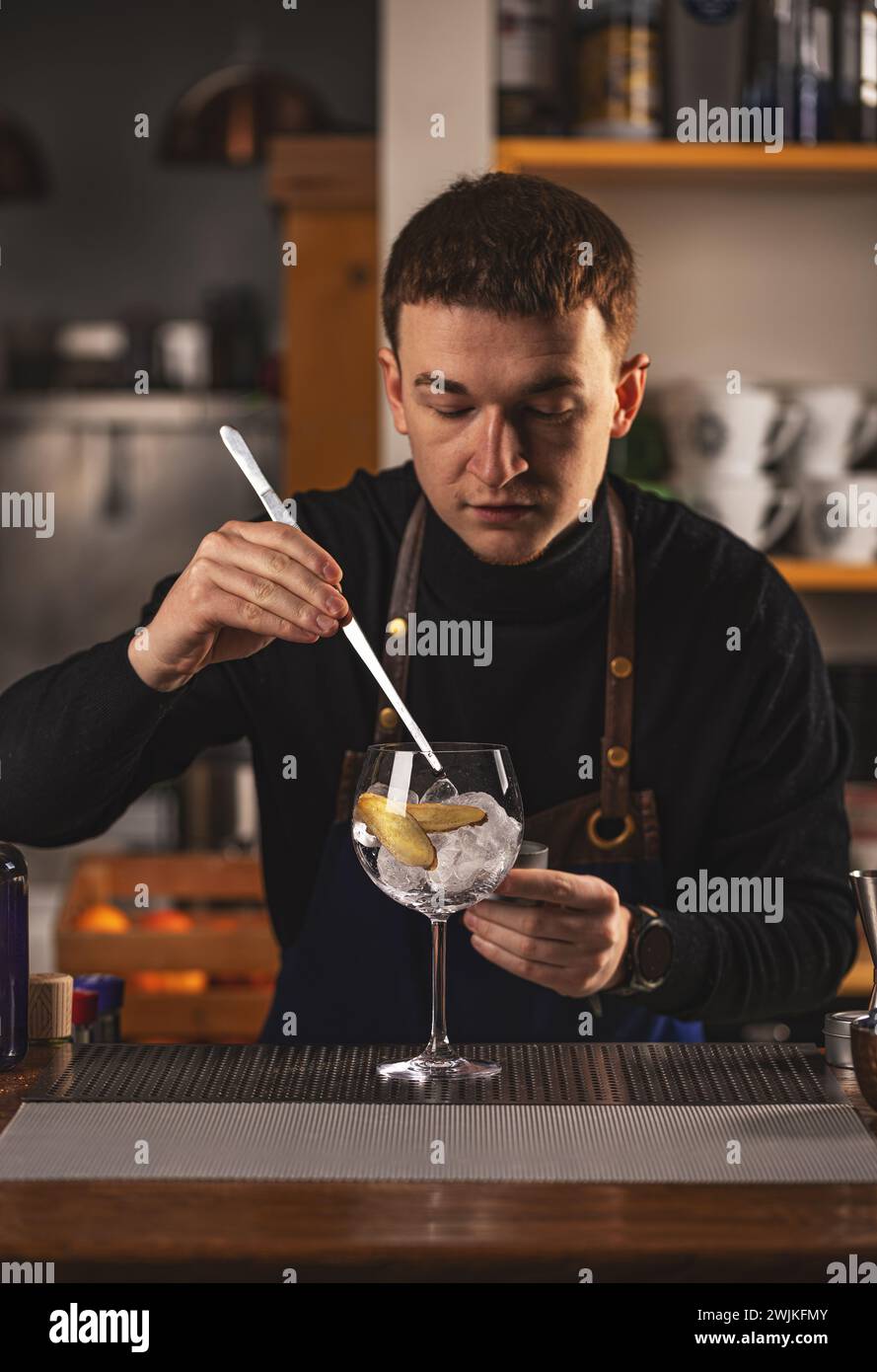 Il giovane barista lavora in un bar che ha preparato un cocktail. Foto Stock Il giovane barista lavora in un bar che ha preparato un cocktail. Foto Stock