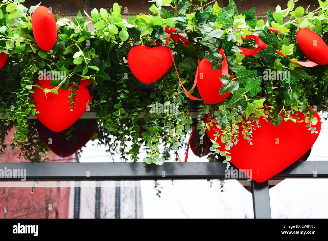 fioritura dell'amore in ogni petalo e fiori verdi in vaso con cuori e gioia del giardino con magia floreale. Momenti pieni di fascino e amore per l'arragement del giardino Foto Stock