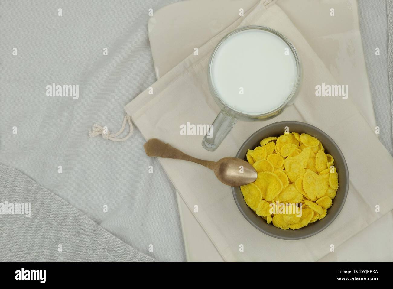 Cereali per la colazione. Fiocchi di mais in ciotole e tazza di latte su uno sfondo chiaro. Fast food. Vista dall'alto. Foto Stock