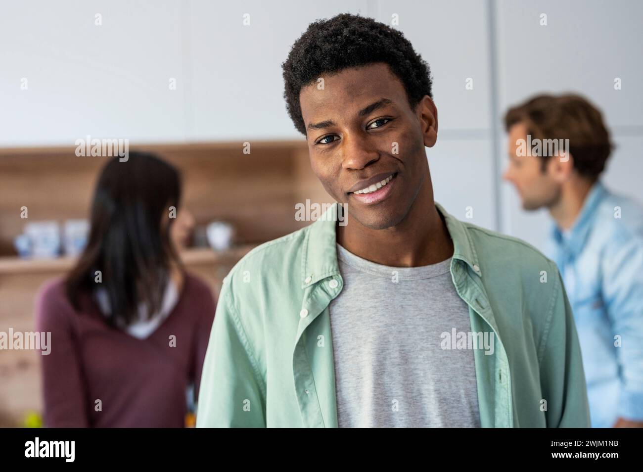 Un giovane adulto sorridente e guarda la macchina fotografica Foto Stock