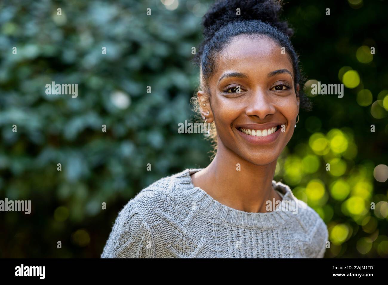 Allegra giovane donna adulta che guarda la fotocamera mentre si trova all'aperto Foto Stock