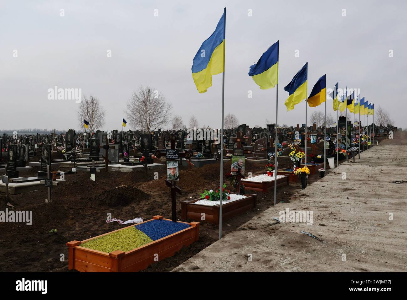 Vista delle tombe dei soldati caduti delle forze armate ucraine nel cimitero di Zaporizhzhia. In due anni di guerra in Ucraina dall'invasione russa del 24 febbraio 2022, decine di migliaia di soldati e civili hanno perso la vita. Il numero esatto di vittime è impossibile da stabilire, con entrambe le parti che forniscono poche informazioni sulle loro perdite, per evitare di minare il morale tra le truppe e il pubblico più ampio. Mentre l'invasione su vasta scala della Russia si aggira verso il traguardo dei due anni e apparentemente senza fine a breve. Foto Stock