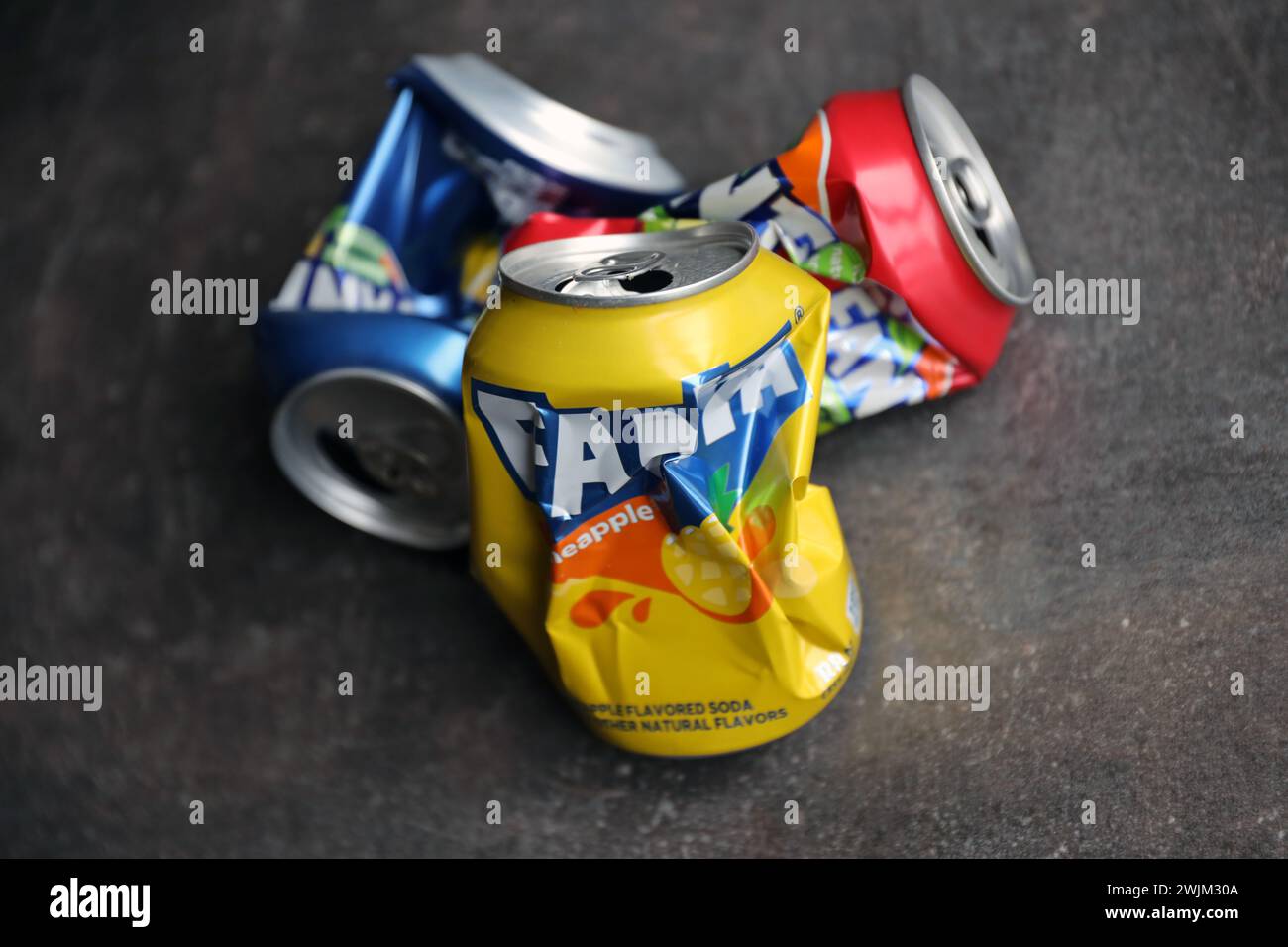 KIEV, UCRAINA - 4 MAGGIO 2023: Primo piano di lattine di latta crumpled di marca di bibite analcoliche Fanta con vari sapori Foto Stock