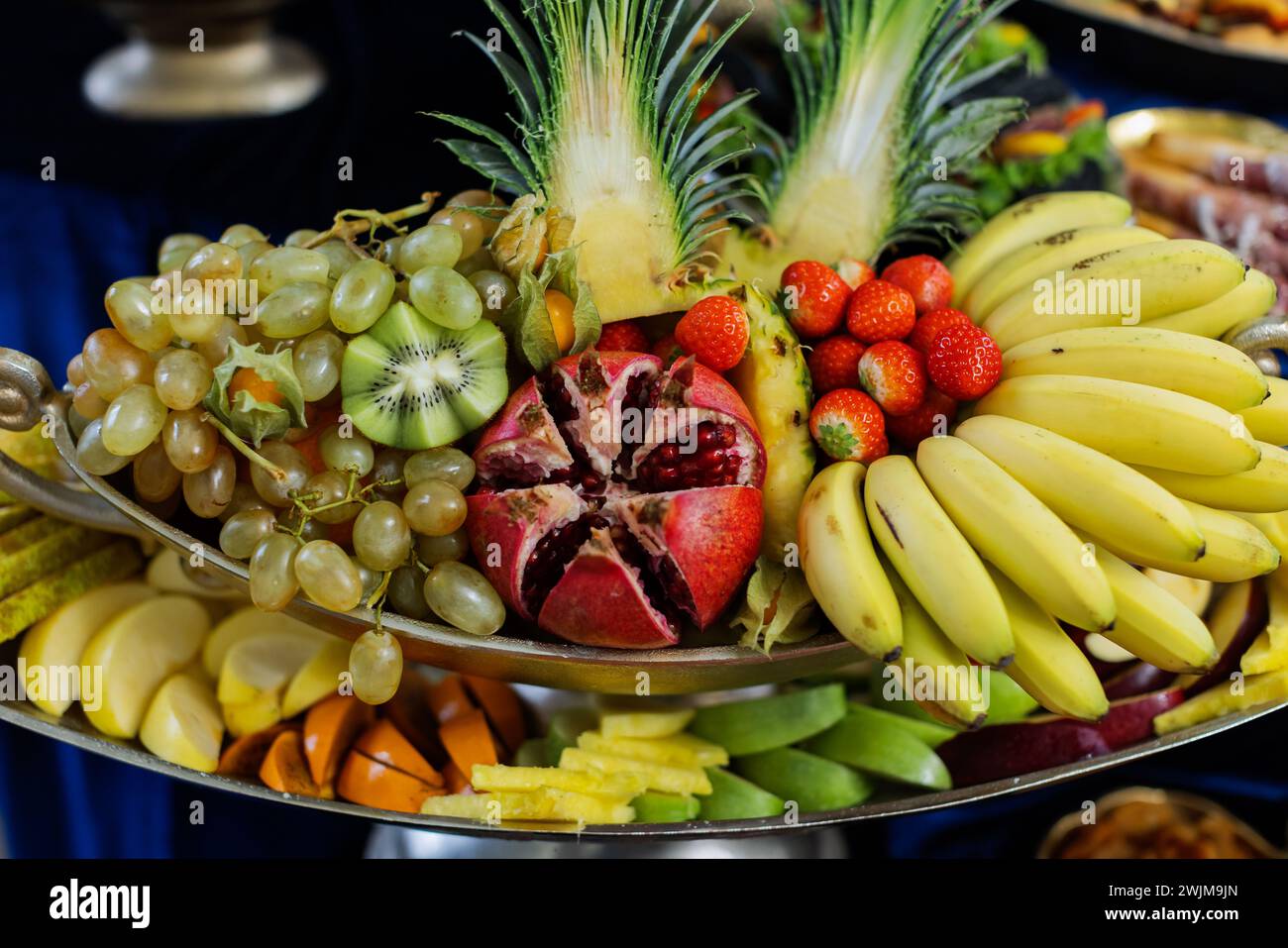 Un piatto ripieno di una varietà di frutta fresca, tra cui uva, banane e ananas Foto Stock