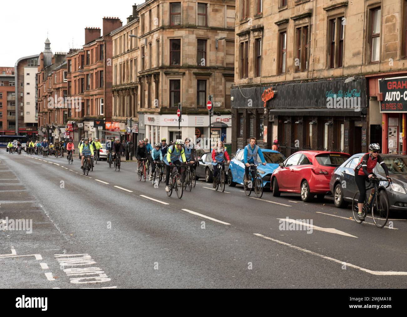 Centinaia di ciclisti e persone con bici su Byres Road, all'estremità occidentale di Glasgow, pedalano per le strade per protestare e dimostrare di essere più sicuri Foto Stock