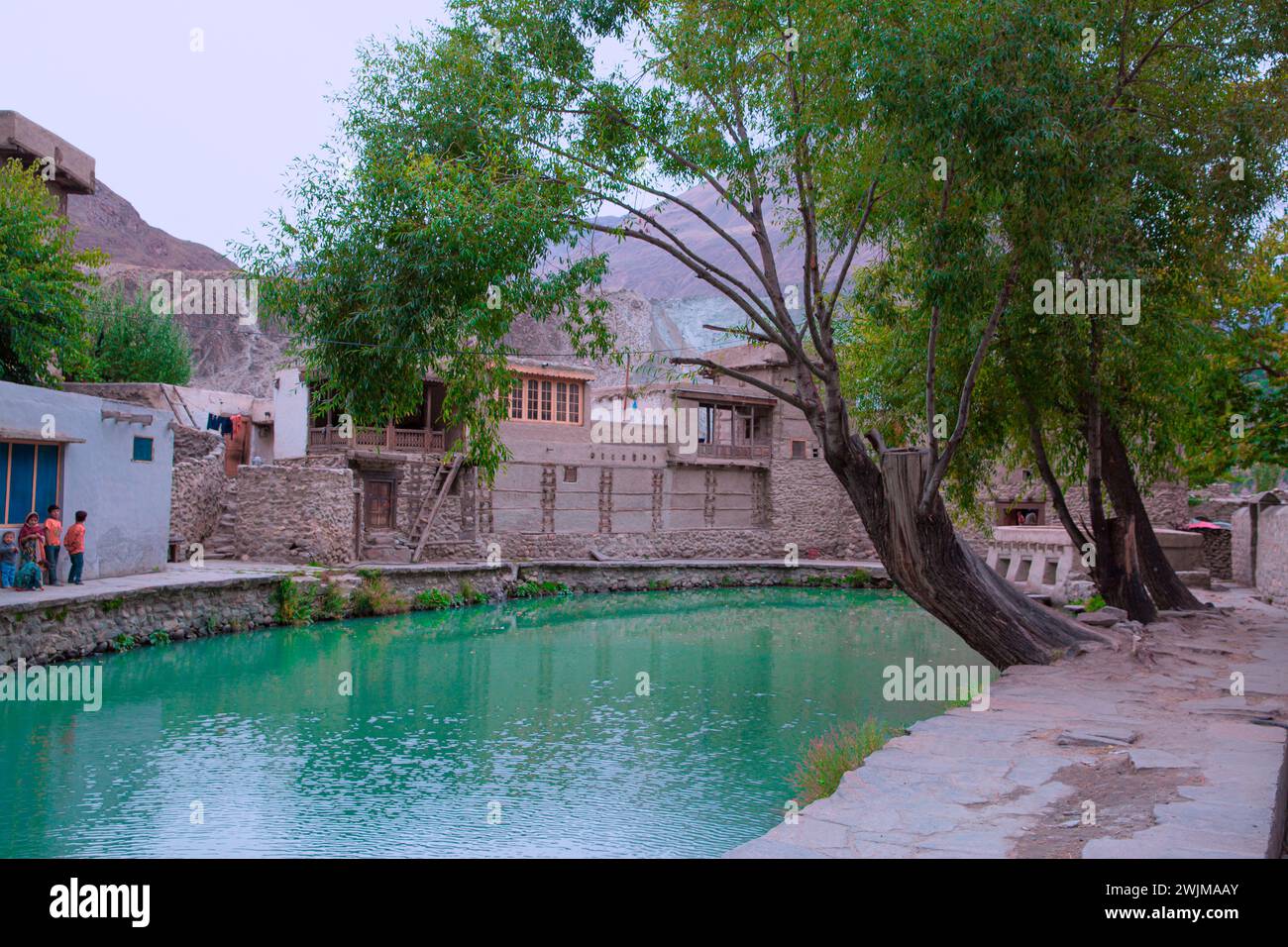 29 di settembre 2023, villaggio di Ganish, Pakistan. Bambini locali in abiti tradizionali e splendide acque turchesi. Foto Stock