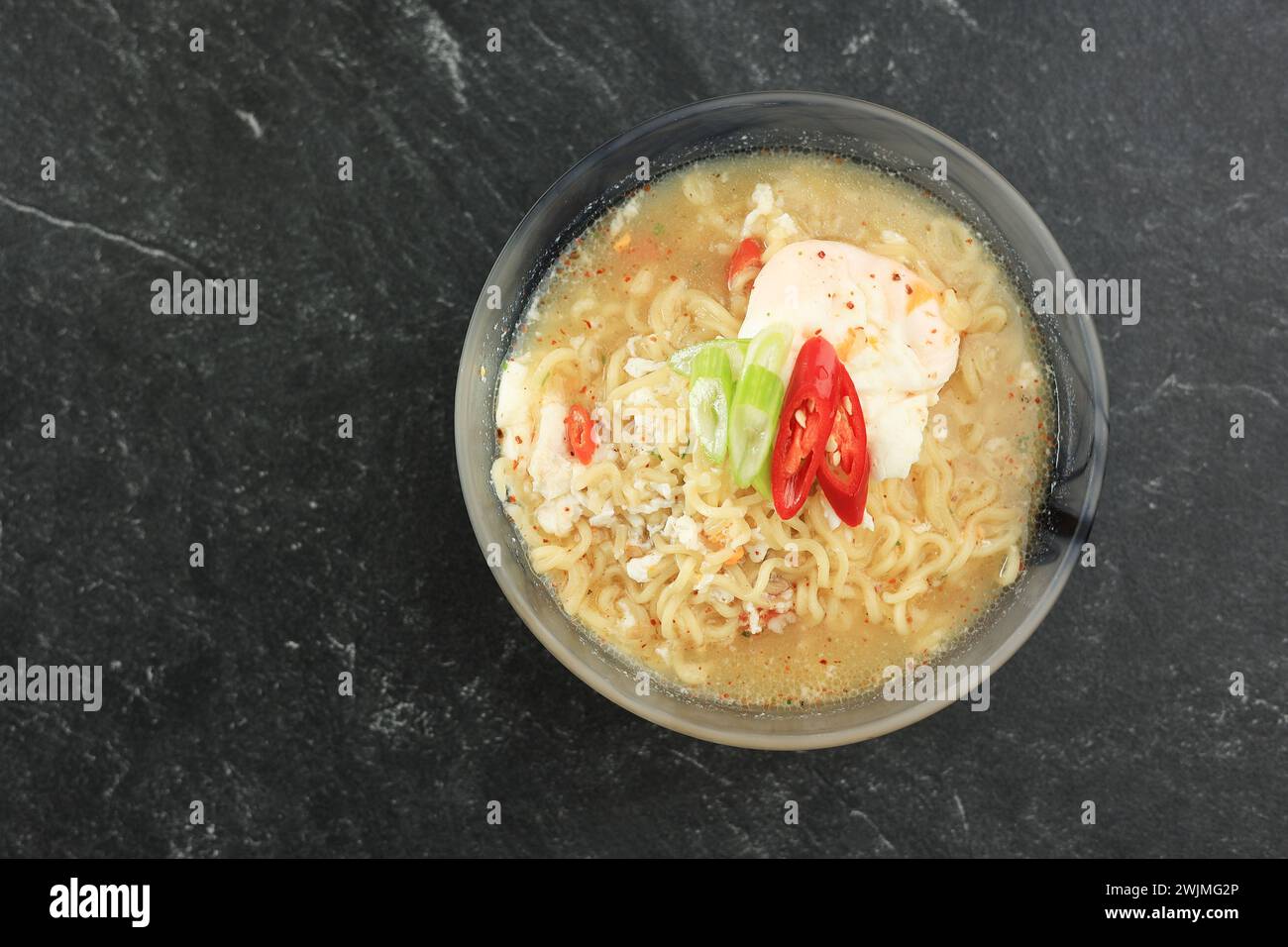 Top View mie Rebus, spaghetti indonesiani istantanei speziati con uovo al forno e peperoncini. Copia spazio per il testo. Foto Stock