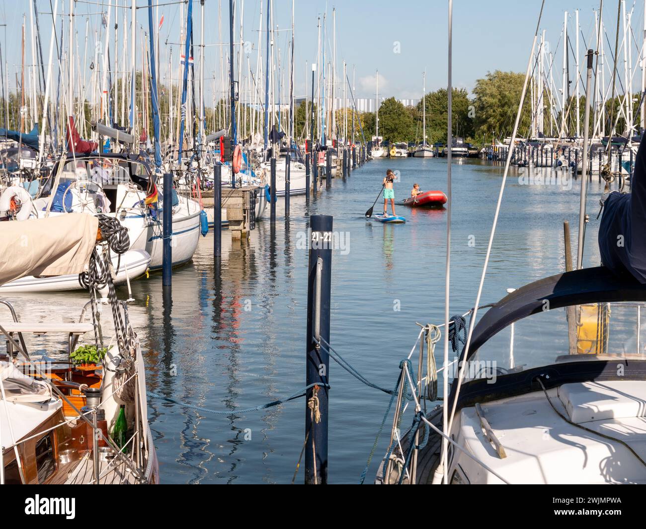 Marina Makkum con molte barche a vela e bambini da gioco, Makkum, Frisia, Paesi Bassi Foto Stock