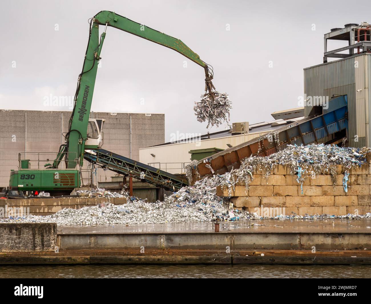 I rottami di stagno vengono raccolti con una gru per essere trattenuti in una fabbrica di riciclaggio di stagno, Leeuwarden Foto Stock