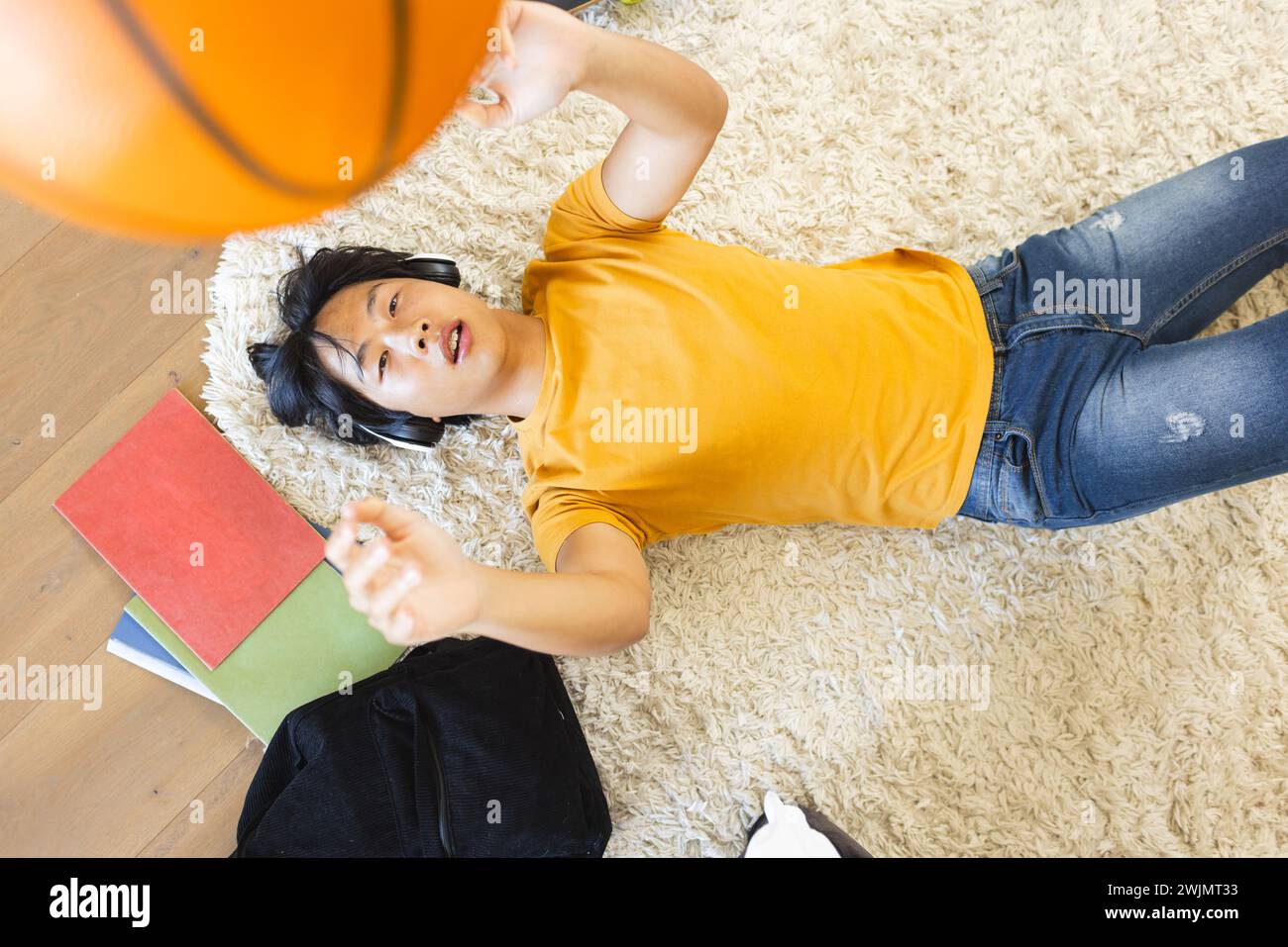 Adolescente ragazzo asiatico gioca con un basket a casa, con spazio di copia Foto Stock