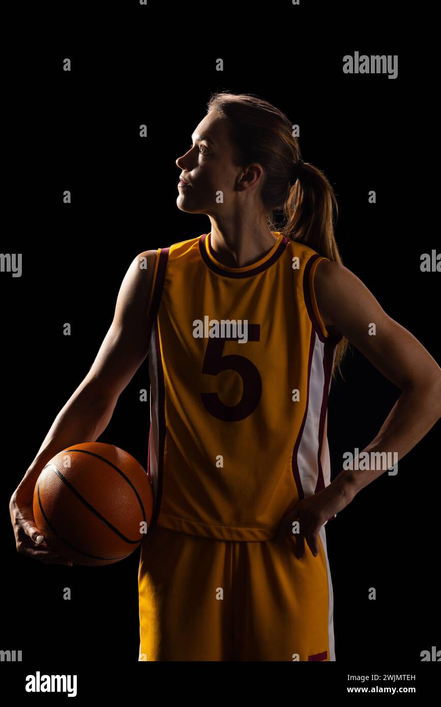 Giocatrice di basket femminile trasuda determinazione in uniforme. Foto Stock