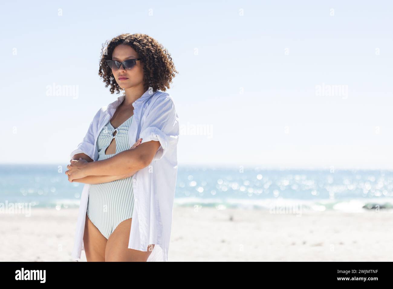 La giovane donna birazziale sta in piedi con sicurezza sulla spiaggia, con spazio di copia inalterato Foto Stock