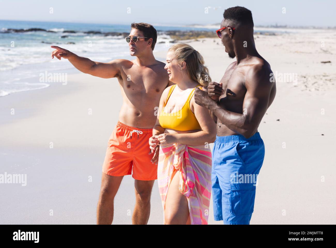 Giovane donna caucasica con diversi amici in spiaggia Foto Stock