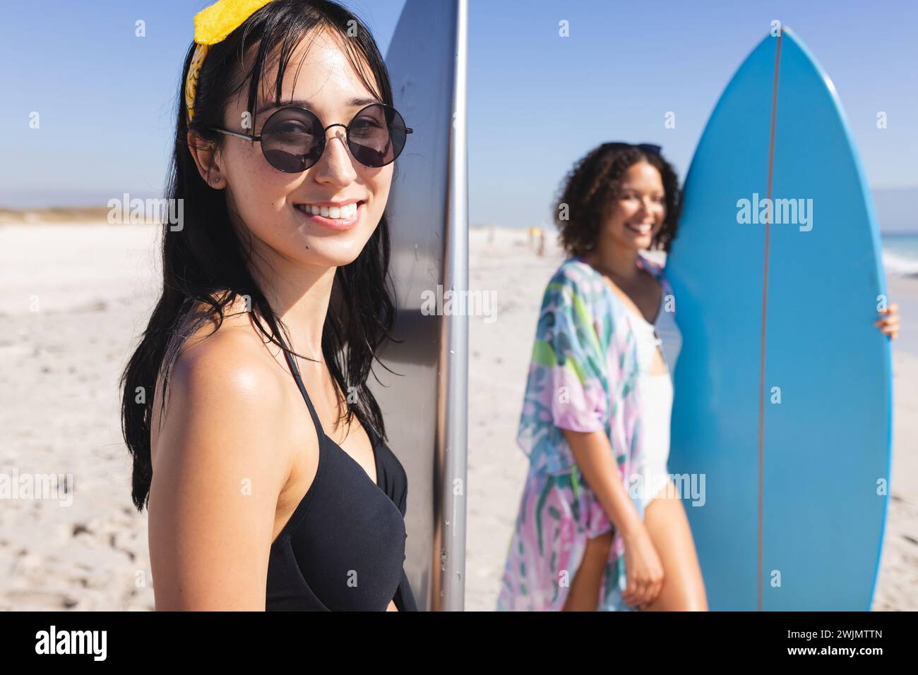 Le giovani donne birazziali si godono una giornata di sole sulla spiaggia Foto Stock