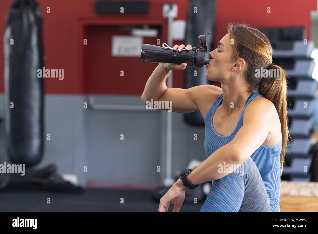 Gli appassionati di fitness si idratano in palestra Foto Stock