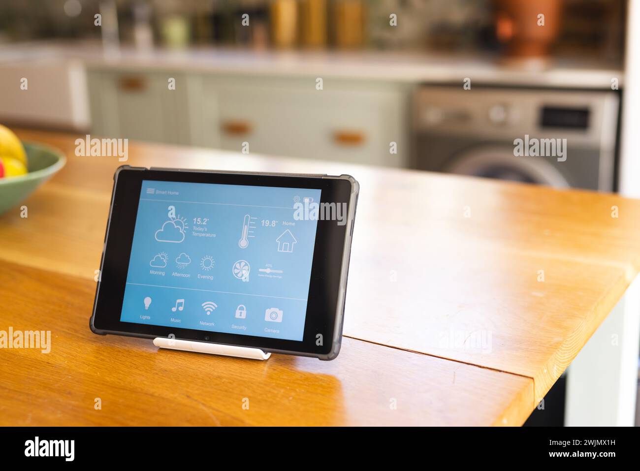 Un tablet visualizza un'interfaccia domestica intelligente in una cucina moderna Foto Stock