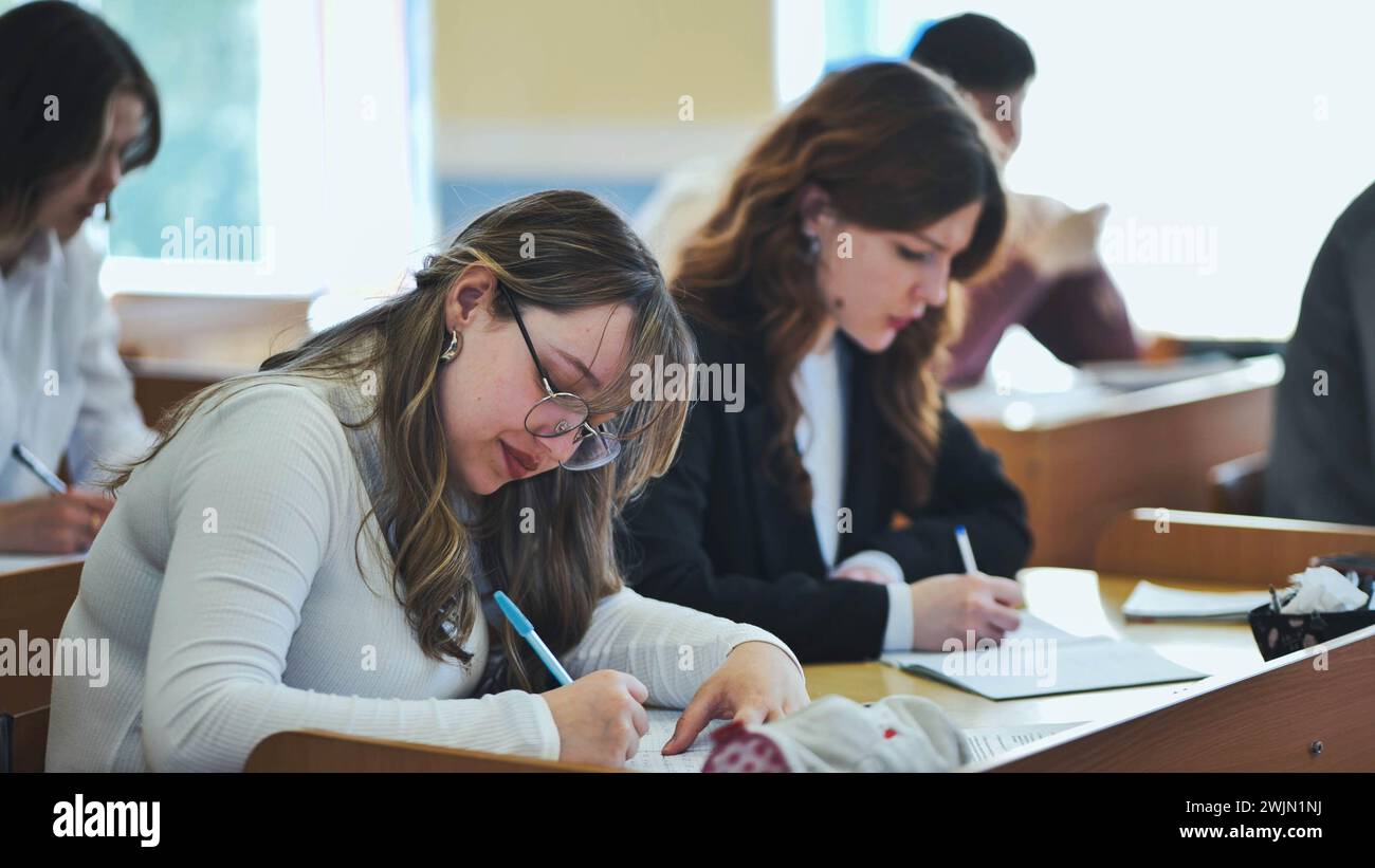 Studentesse che scrivono formule matematiche in un taccuino. Foto Stock