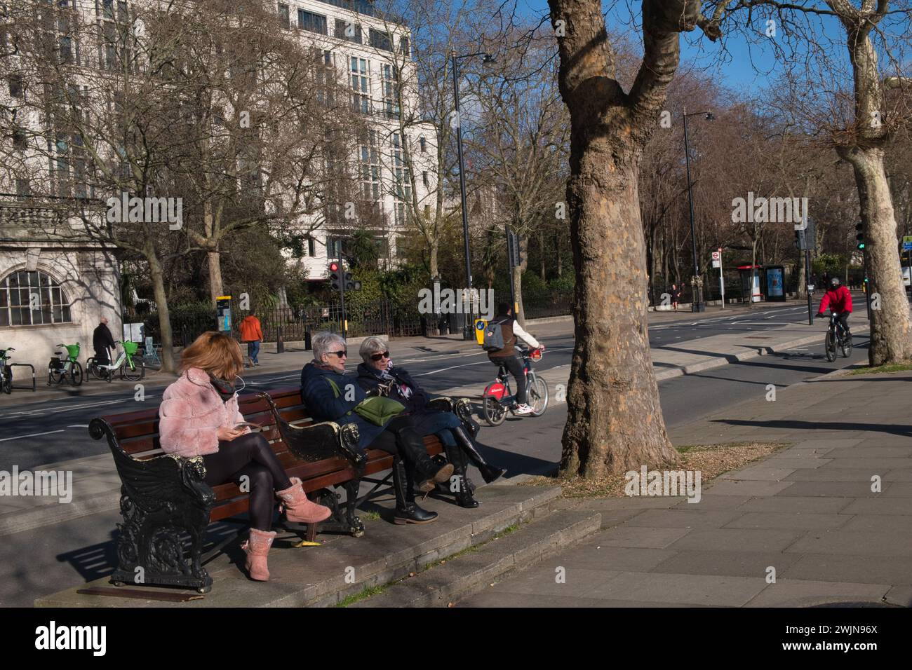 Donne sedute in panchina lungo l'Embankment a Londra in inverno Foto Stock