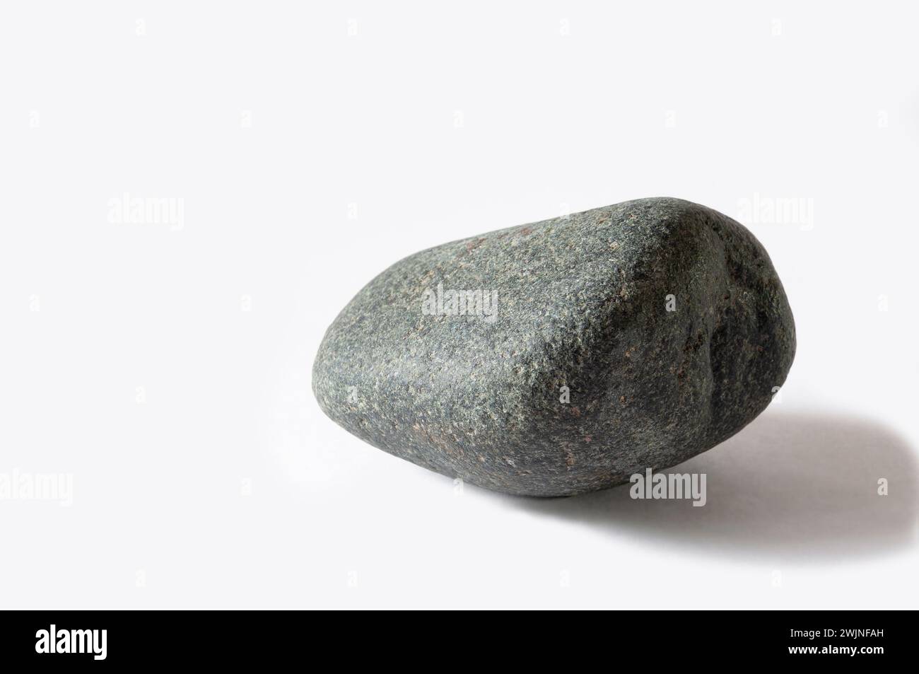 Pietra grigia scura dal fondo del mare su sfondo bianco. Foto Stock