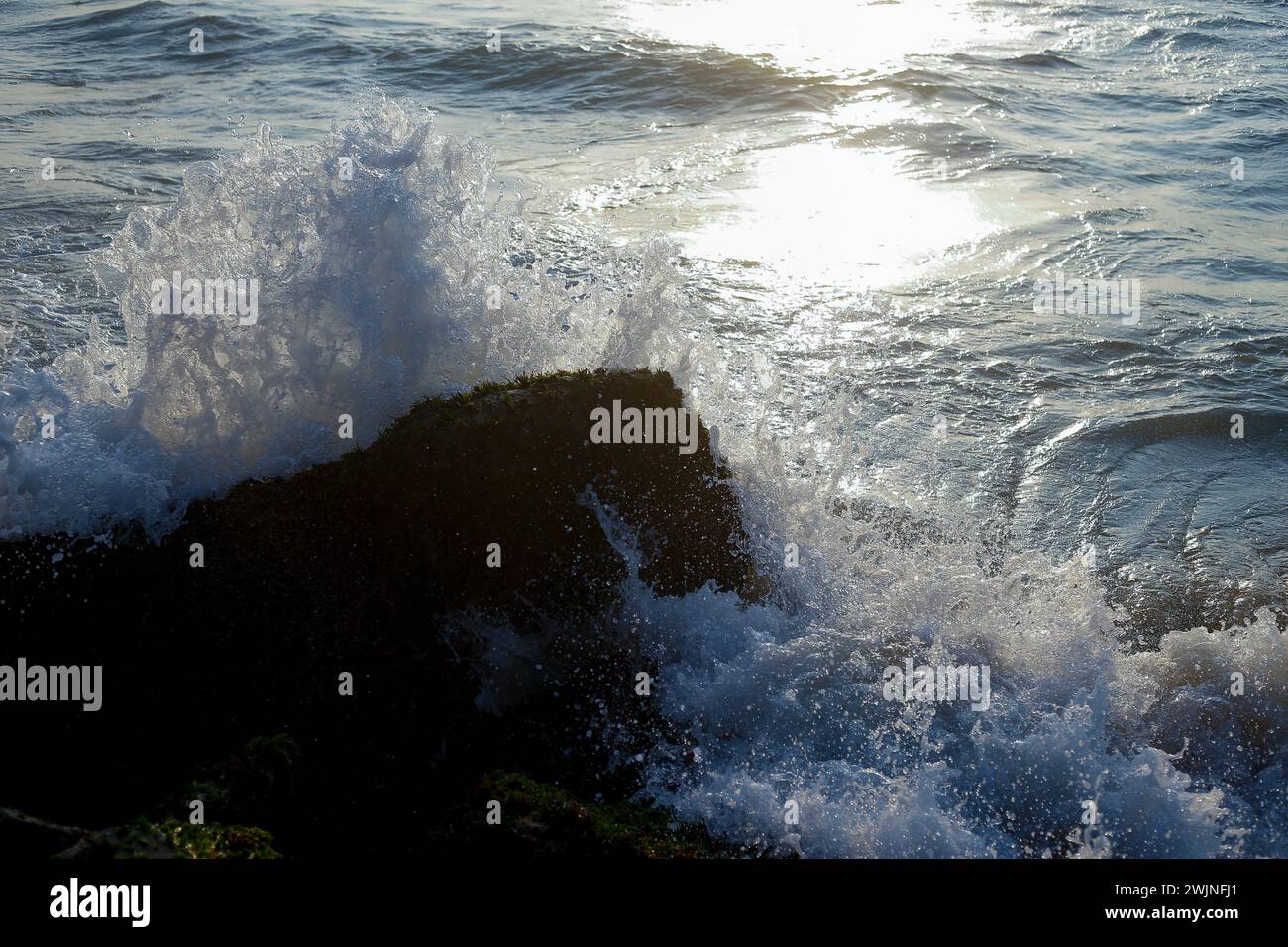 Massi di pietra sulla costa con il sole dell'Oceano indiano. Foto Stock