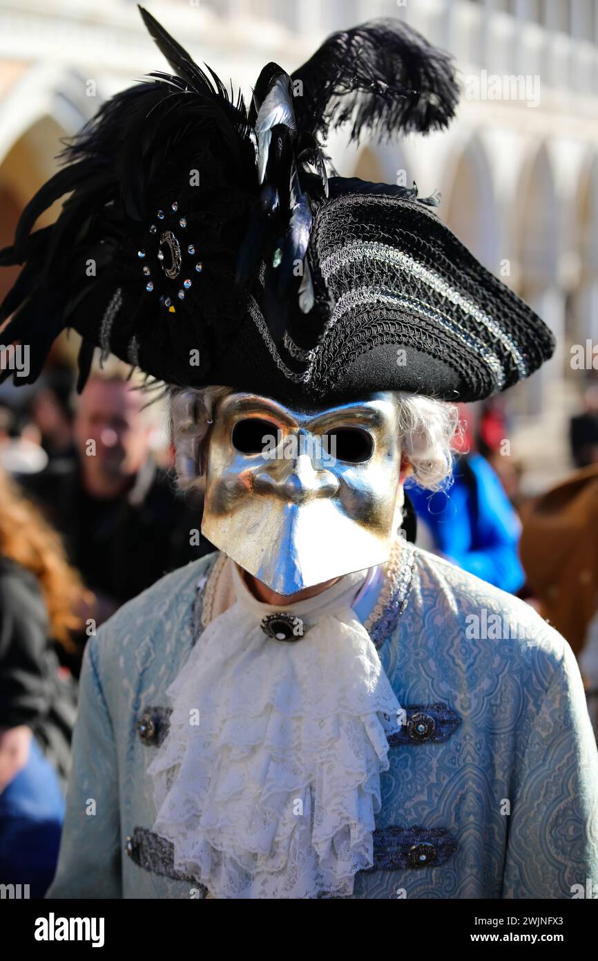 Venezia, VE, Italia - 13 febbraio 2024: Persona mascherata con grande rumore e cappello nero al Carnevale Foto Stock