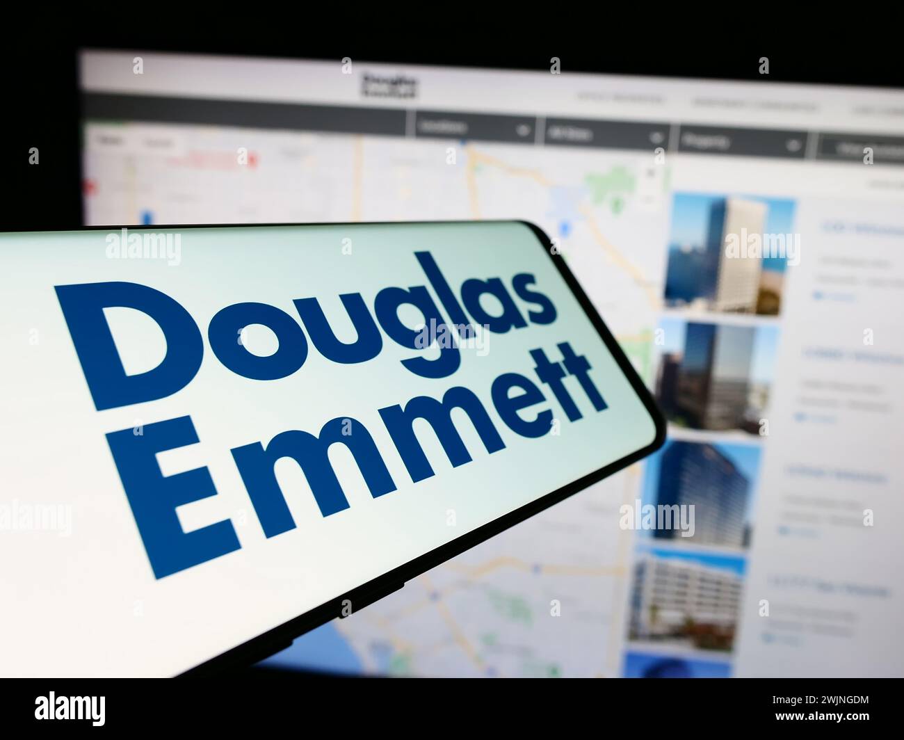 Telefono cellulare con logo della società immobiliare americana Douglas Emmett Inc. Davanti al sito Web aziendale. Mettere a fuoco la parte centrale sinistra del display del telefono. Foto Stock