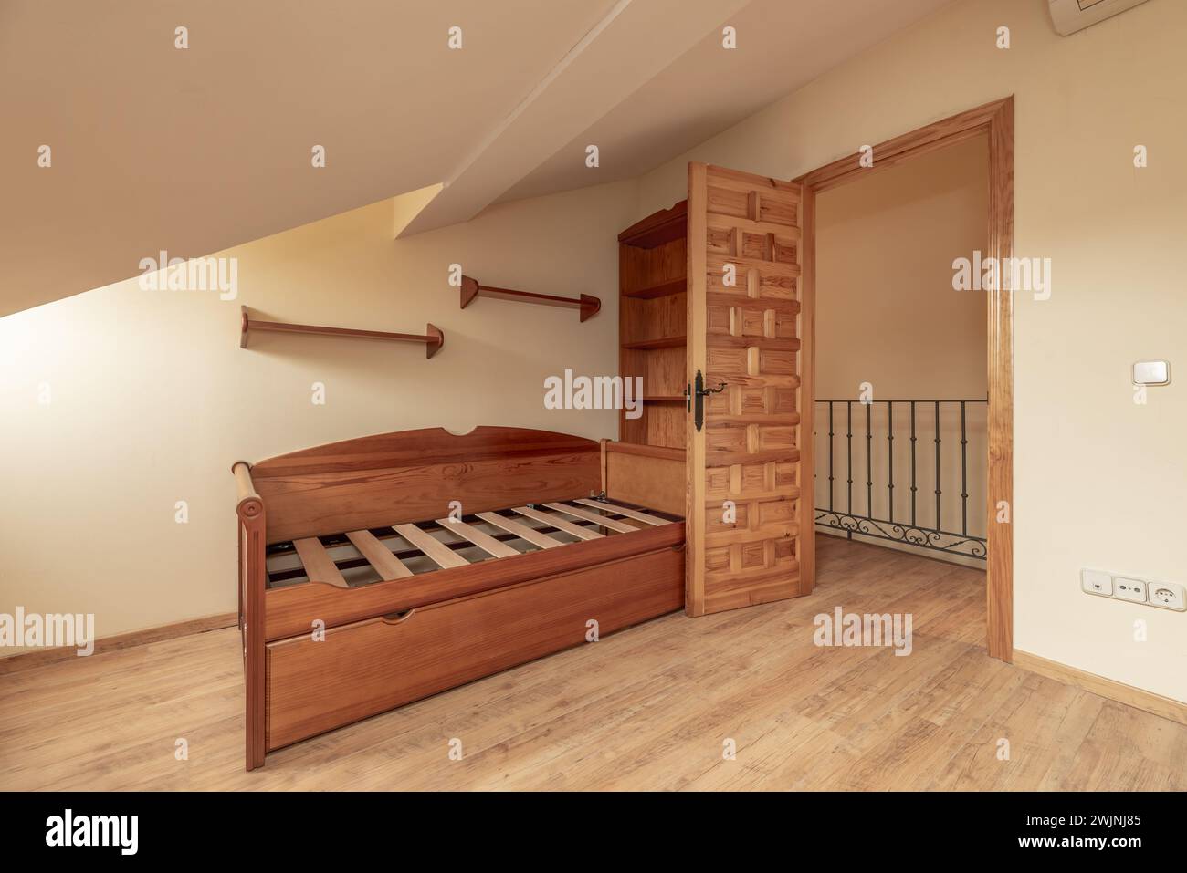 Camera da letto con decorazioni in legno castigliano, letti giovani senza materassi e soffitti inclinati Foto Stock