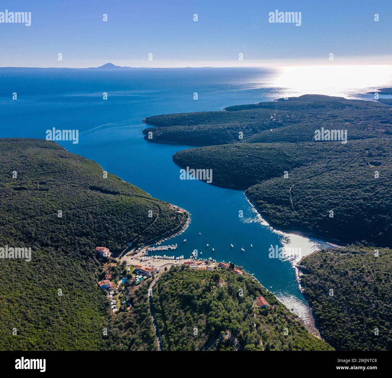 Una prospettiva aerea mozzafiato che mostra un lago tranquillo e maestose montagne nel villaggio di Krnica, nel sud-est dell'Istria, in Croazia Foto Stock