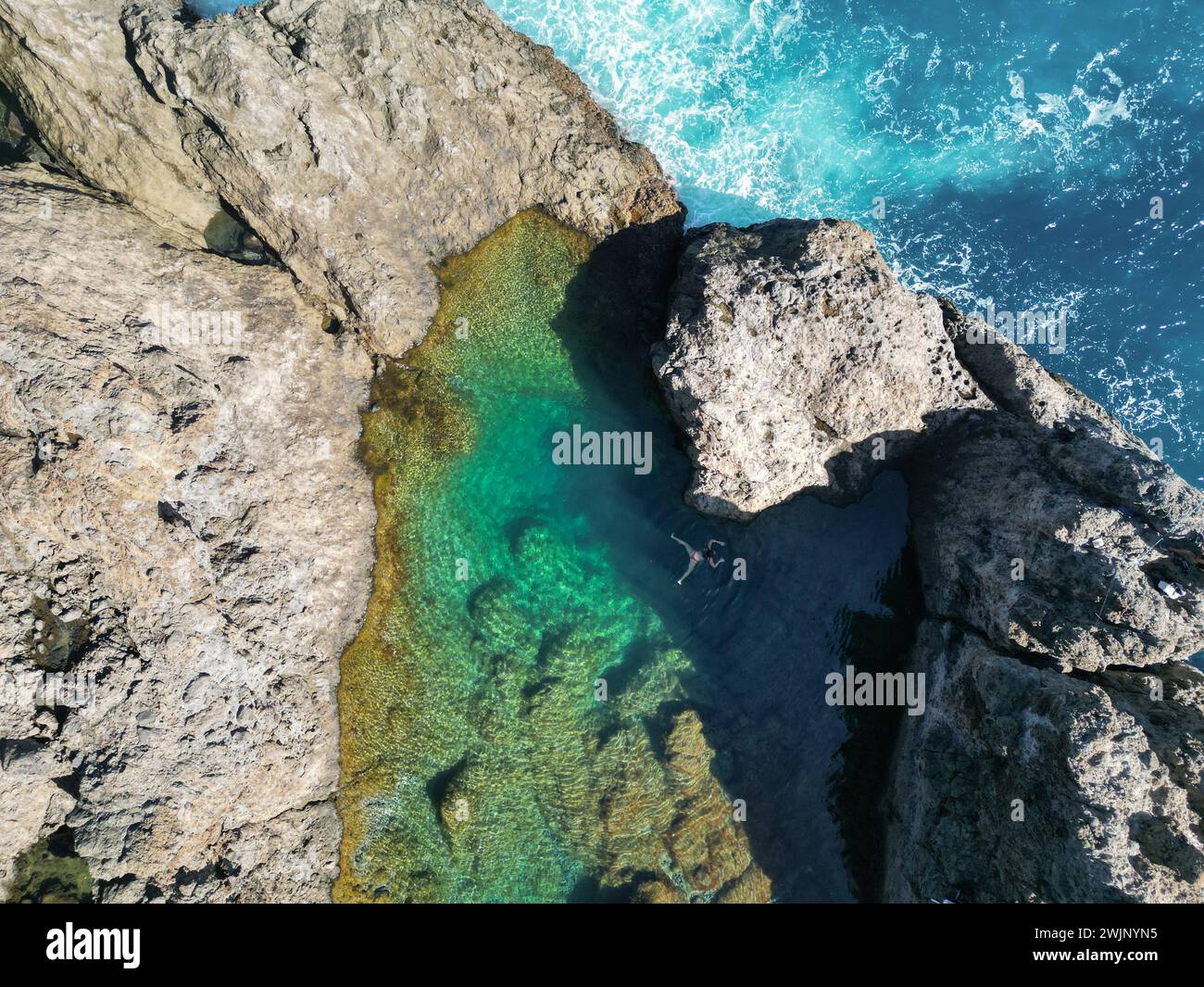 Vista aerea di una splendida piscina naturale con acque cristalline e una persona che nuota. Tenerife, Isole Canarie Foto Stock