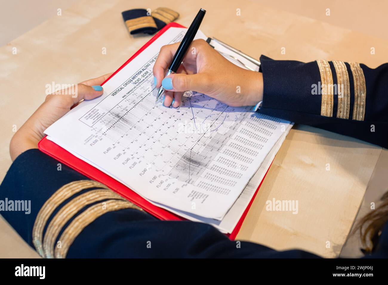 Pilota femminile irriconoscibile che prepara la documentazione di volo con un portachiavi Rimuovi prima del volo. Foto di alta qualità Foto Stock