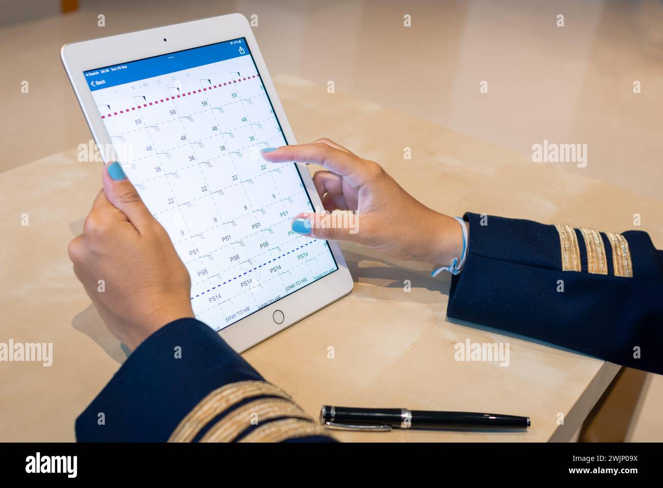 Pilota femminile irriconoscibile che prepara la documentazione di volo su un tablet. Borsa elettronica per il volo. Messa a fuoco selettiva. Foto di alta qualità. Foto Stock