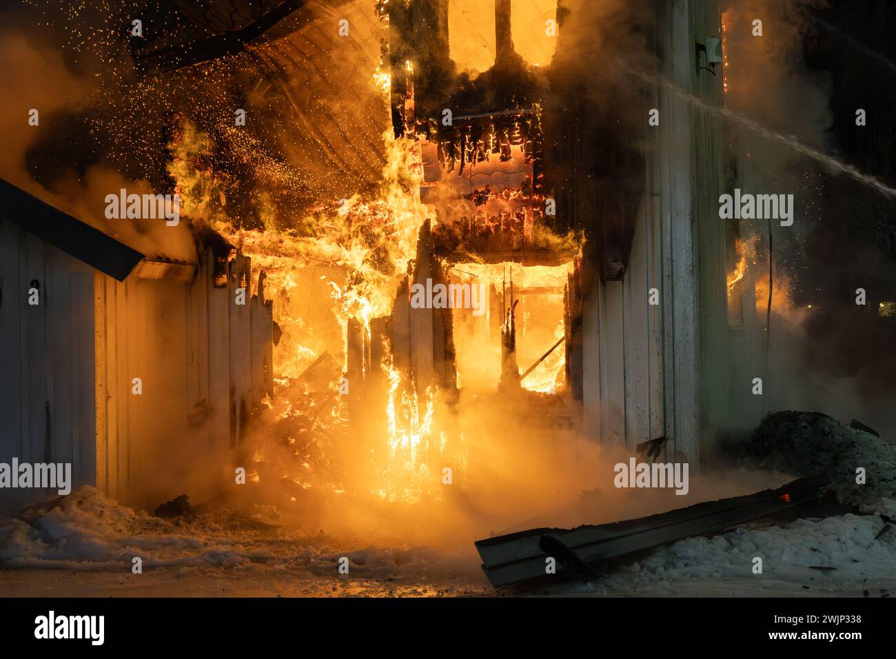 Vigili del fuoco che affrontano il fuoco, danno fuoco a casa nella ghiacciata e nevosa Oslo, Norvegia Foto Stock