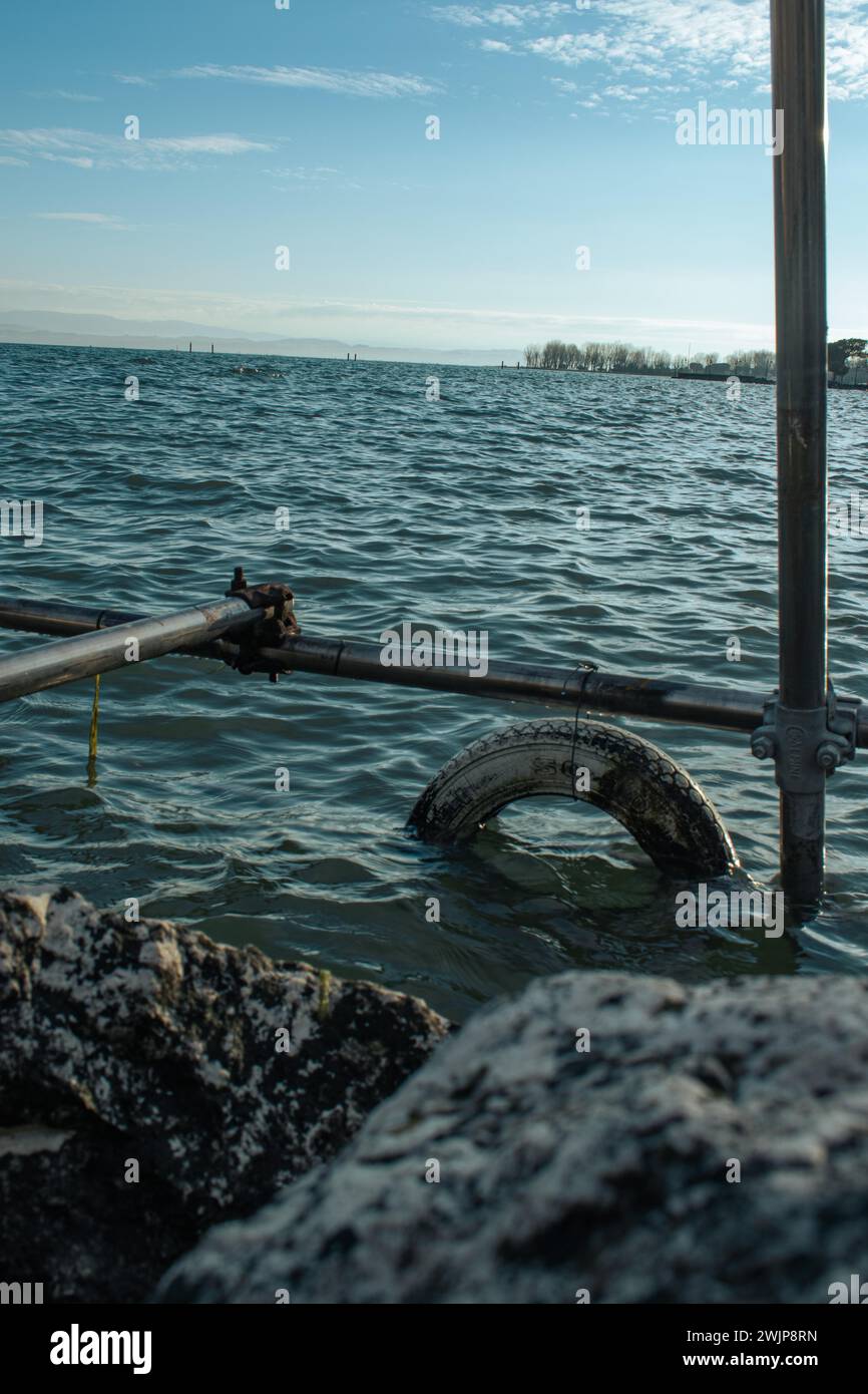 Veduta del Lago di Garda con uno pneumatico legato alla ringhiera in acqua, Sirmione, Lago di Garda, Italia Foto Stock